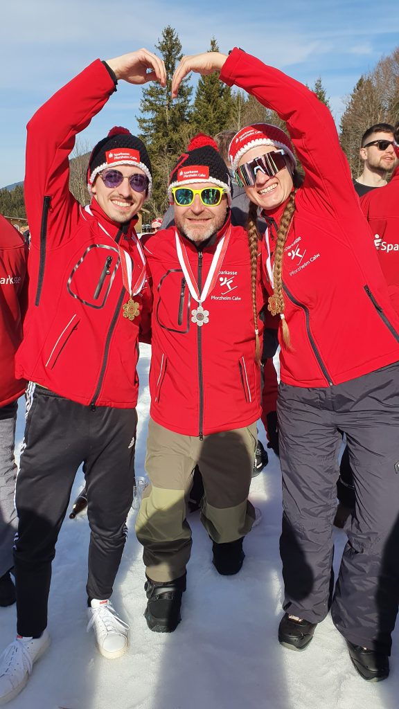 Eric Müller, Holger Pfau und Inken Wetzel mit Medaillen. Eric und Inken formen ein Herz mit den Armen. Alle Lachen. 